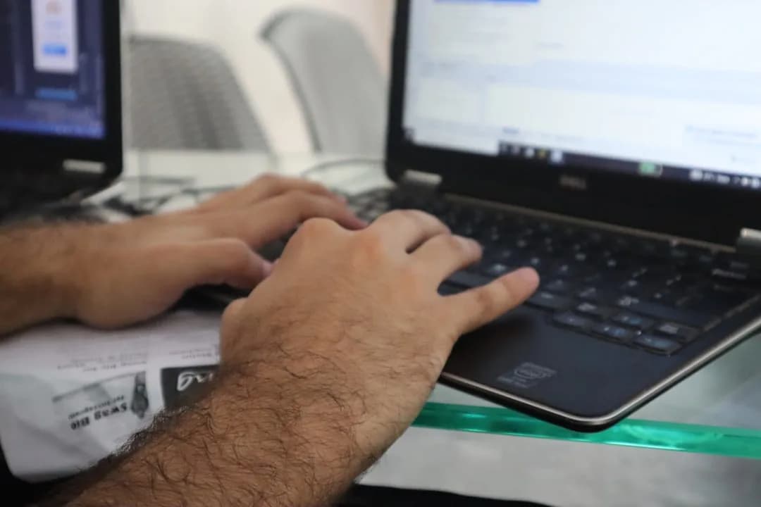 Pessoa digitando em um laptop, representando a realização de um teste vocacional online