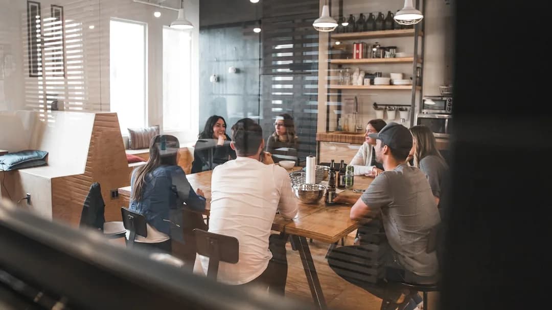 Grupo de pessoas sentadas em conversa colaborativa, representando o perfil Aliada que une e apoia equipes